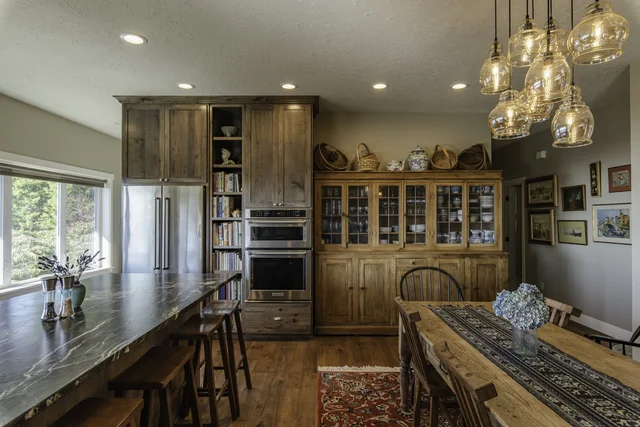 Tall fitted storage and integrated appliances in warm wood